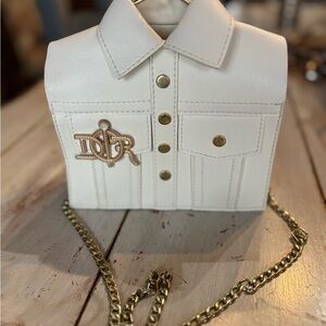 Crème shirt with gold chain cross bag